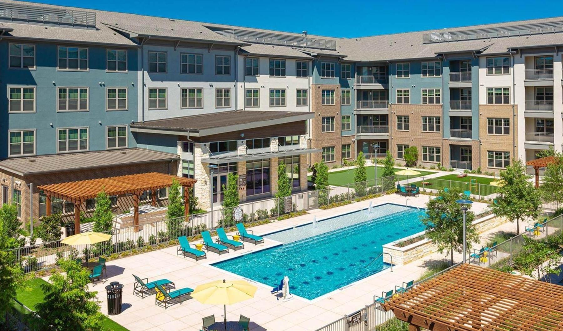 Shimmering resort-style pool a large building with a pool