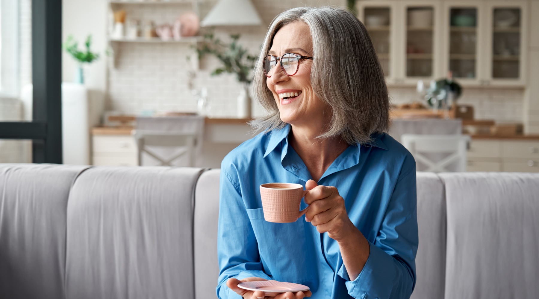 a woman smiling holding a mug