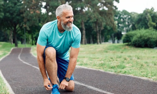A man outside for a run on a walking trail