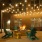 The outdoor lounge at our senior living apartments in Plano, TX, featuring a fire pit, chairs, and string lights.