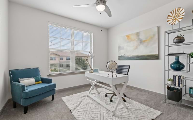 A room with bright light, desk and oversized chair 